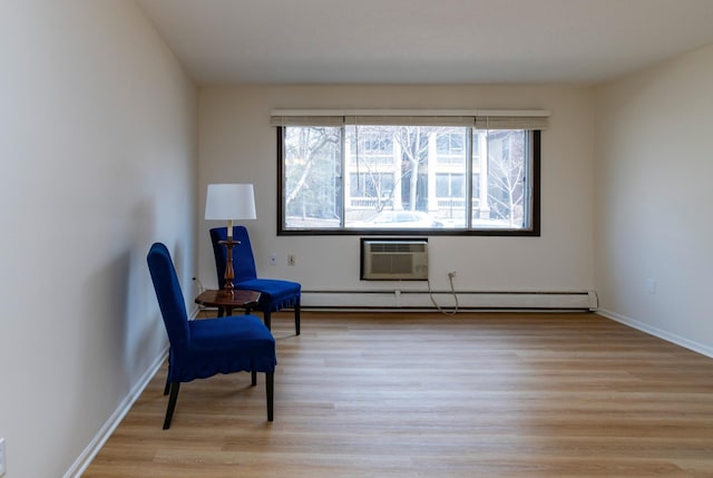 living area with a baseboard radiator, a wall mounted AC, light wood-style floors, and baseboards
