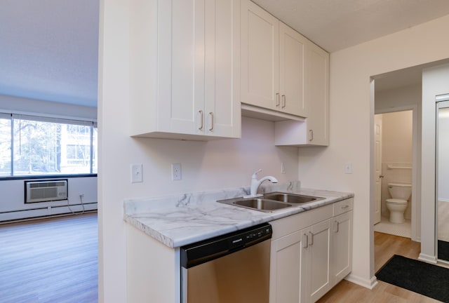 kitchen with a sink, light countertops, stainless steel dishwasher, and light wood-style flooring