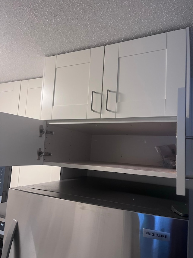 2446 Aldrich Ave S Unit 111, Minneapolis, MN 55405 - kitchen view of a textured ceiling, white cabinetry, and fridge