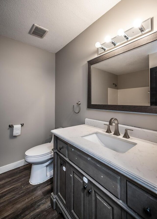 32955 County 24th Blvd, Cannon Falls, MN 55009 - bathroom featuring visible vents, baseboards, toilet, vanity, and wood finished floors