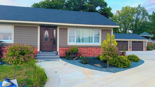 32955 County 24th Blvd, Cannon Falls, MN 55009 - view of front facade featuring an attached garage, driveway, stone siding, and a shingled roof