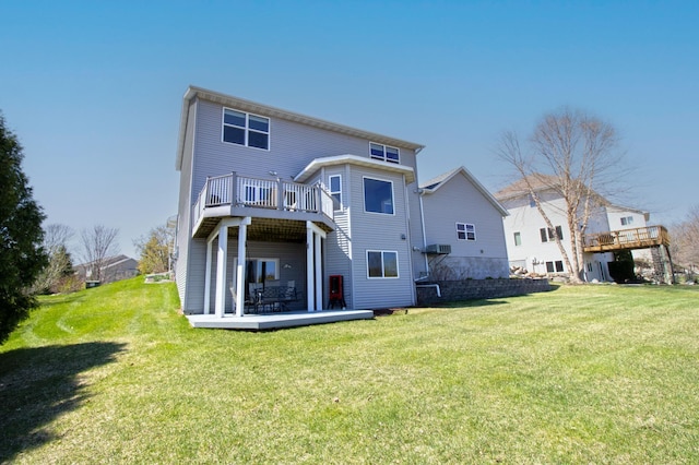 rear view of property with a wooden deck, a yard, and a balcony