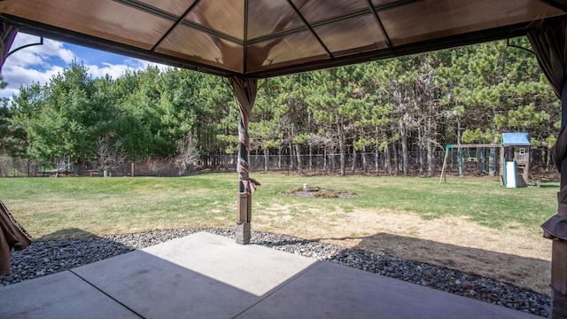 view of yard featuring a patio area, a fenced backyard, and a playground