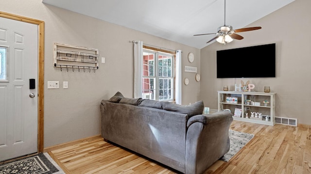 living area featuring wood finished floors, ceiling fan, vaulted ceiling, and visible vents