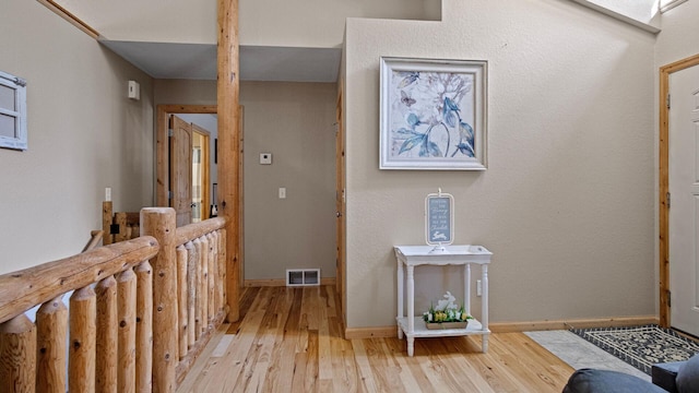 foyer entrance with visible vents, baseboards, and light wood finished floors