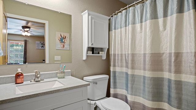 full bathroom with a textured wall, vanity, toilet, and ceiling fan