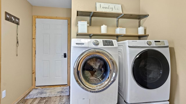 laundry room featuring independent washer and dryer, wood finished floors, laundry area, and baseboards