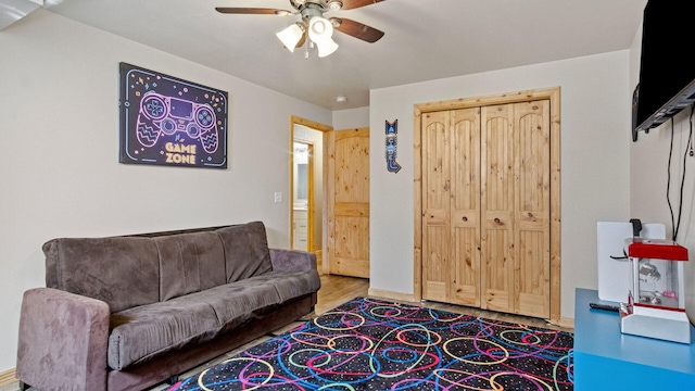living area featuring a ceiling fan and wood finished floors