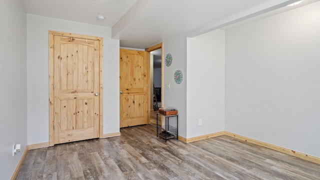 spare room with wood finished floors and baseboards
