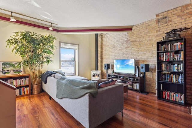 1802 4th Ave S Unit D, Minneapolis, MN 55404 - living area featuring a textured ceiling, rail lighting, wood finished floors, a wood stove, and brick wall