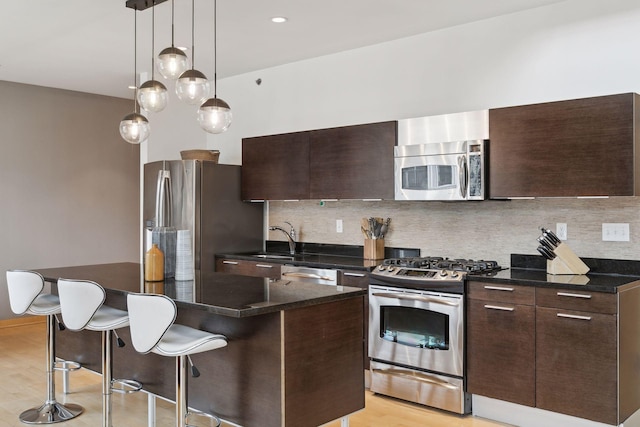 3104 Lake St Unit 410, Minneapolis, MN 55416 - kitchen featuring appliances with stainless steel finishes, dark brown cabinetry, a kitchen bar, modern cabinets, and recessed lighting