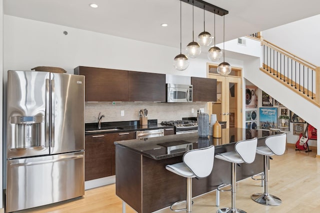 3104 Lake St Unit 410, Minneapolis, MN 55416 - kitchen featuring stainless steel appliances, a breakfast bar, dark brown cabinetry, a center island, and recessed lighting
