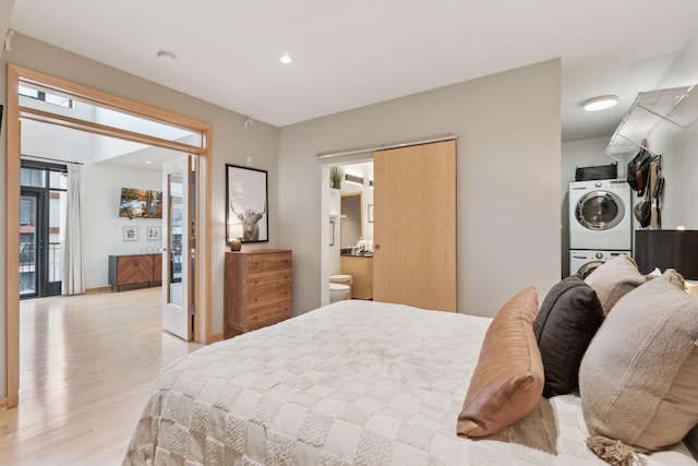 3104 Lake St Unit 410, Minneapolis, MN 55416 - bedroom featuring stacked washer and clothes dryer, light wood-type flooring, recessed lighting, and ensuite bathroom