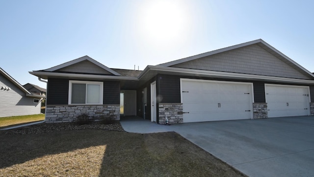 ranch-style house featuring stone siding, a garage, and driveway