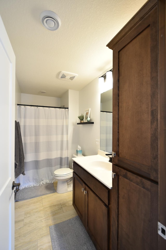 full bathroom featuring vanity, visible vents, toilet, and wood finished floors