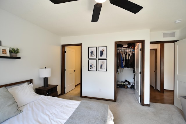 carpeted bedroom with visible vents, a closet, baseboards, a spacious closet, and a ceiling fan