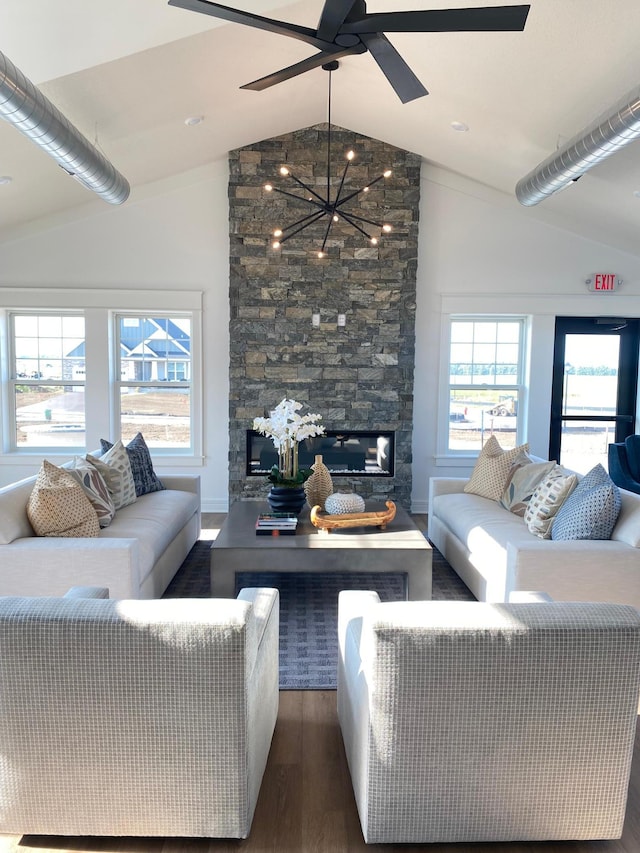 living room featuring baseboards, a fireplace, wood finished floors, ceiling fan with notable chandelier, and lofted ceiling