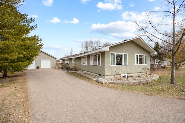 view of front of house featuring driveway, an outdoor structure, and a garage
