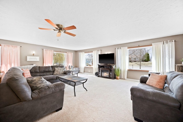 living room with baseboards, ceiling fan, a healthy amount of sunlight, and light carpet
