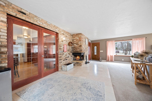 living room featuring french doors, a textured ceiling, a brick fireplace, baseboards, and tile patterned floors