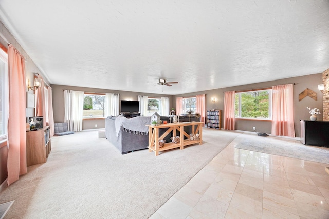 living room featuring baseboards, marble finish floor, ceiling fan, and a wealth of natural light