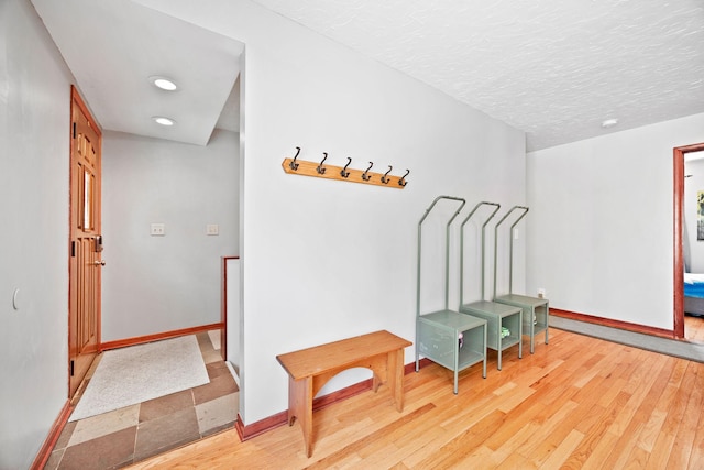 mudroom with baseboards, recessed lighting, a textured ceiling, and light wood-type flooring