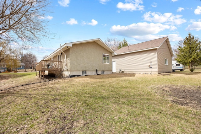 rear view of house with a lawn and a deck