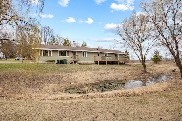 rear view of house featuring a deck and a chimney