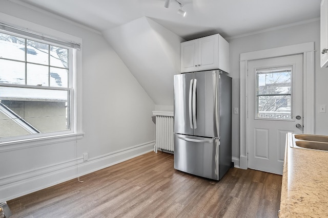 kitchen with freestanding refrigerator, dark wood-type flooring, radiator heating unit, white cabinetry, and light countertops