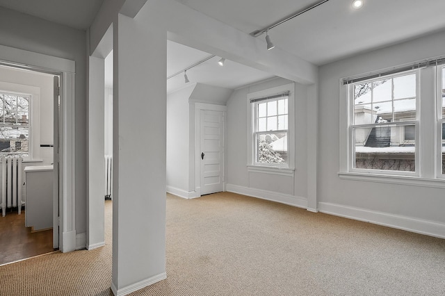 additional living space featuring radiator heating unit, carpet flooring, and baseboards