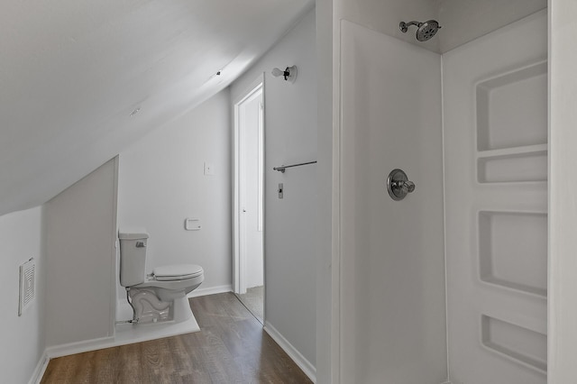 bathroom featuring toilet, wood finished floors, baseboards, and a shower