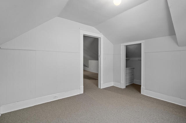 additional living space with carpet flooring and lofted ceiling