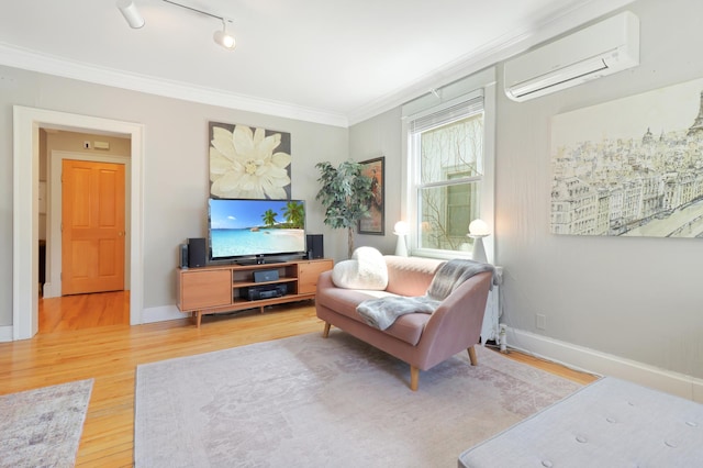 living room featuring baseboards, ornamental molding, wood finished floors, and a wall mounted AC