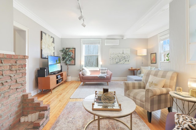 living room featuring light wood finished floors, a wall unit AC, and crown molding
