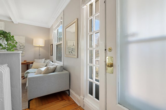 entryway with an AC wall unit, crown molding, wood finished floors, and beam ceiling