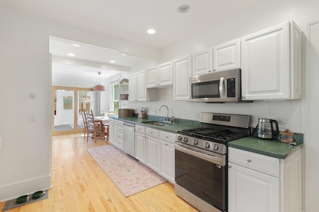 kitchen featuring decorative backsplash, stainless steel appliances, a sink, and dark countertops