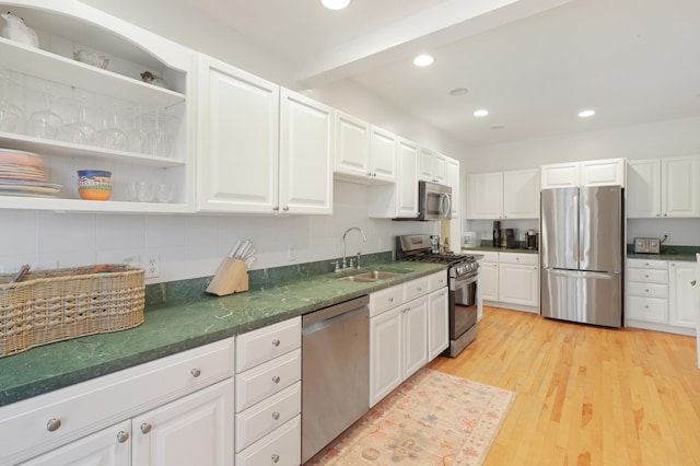 kitchen with dark countertops, appliances with stainless steel finishes, tasteful backsplash, and a sink