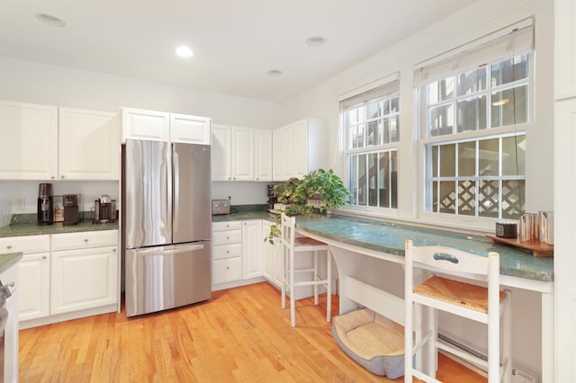 kitchen with freestanding refrigerator, light wood-style floors, and white cabinetry