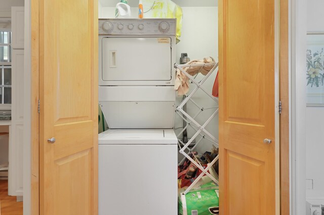 clothes washing area with stacked washer / drying machine and laundry area