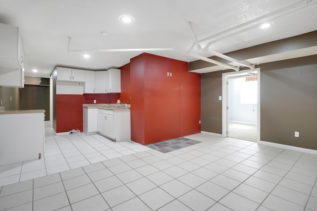 kitchen with light tile patterned floors, light countertops, white cabinets, baseboards, and recessed lighting