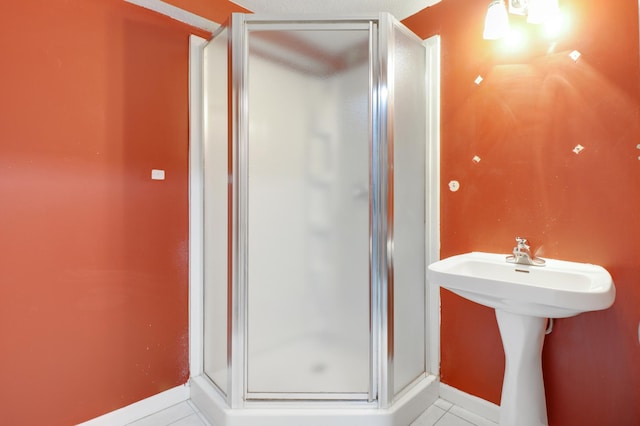 full bath featuring a shower stall, baseboards, and tile patterned flooring