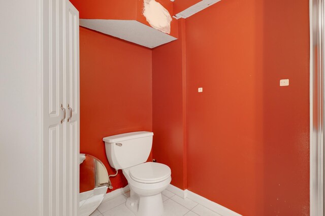 bathroom featuring tile patterned floors, baseboards, and toilet