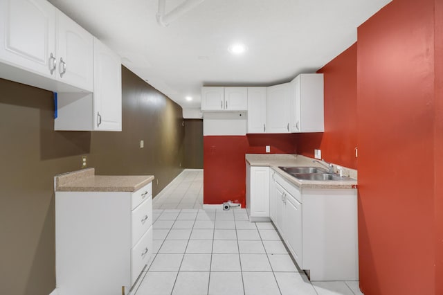 kitchen with recessed lighting, light countertops, light tile patterned floors, a sink, and white cabinetry