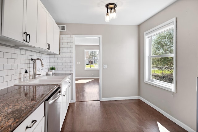 kitchen featuring a sink, backsplash, dishwasher, and a healthy amount of sunlight