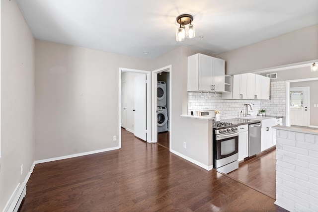 kitchen featuring stacked washer and dryer, open shelves, appliances with stainless steel finishes, dark wood-type flooring, and visible vents