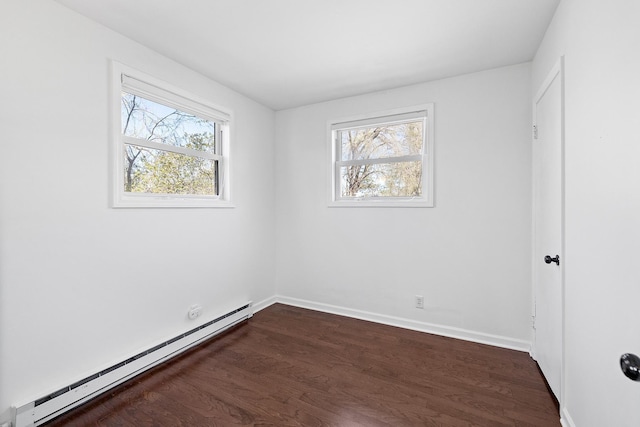 unfurnished room with baseboards, baseboard heating, and dark wood finished floors