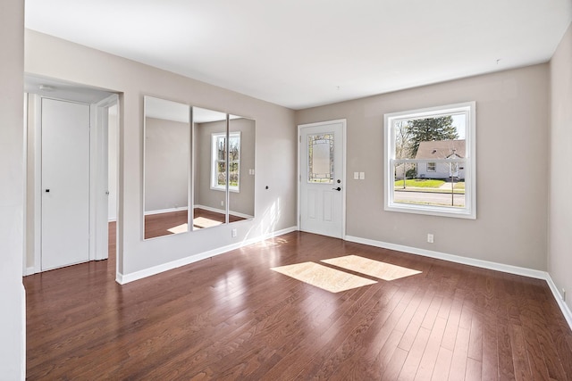 entrance foyer featuring dark wood-style flooring, baseboards, and a healthy amount of sunlight