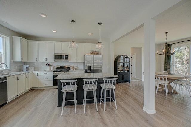 11422 34th St N, Lake Elmo, MN 55042 - kitchen with stainless steel appliances, decorative backsplash, light wood-type flooring, and recessed lighting