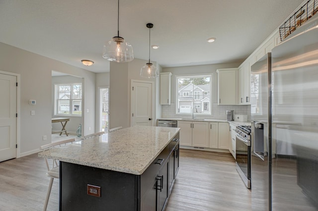 11422 34th St N, Lake Elmo, MN 55042 - kitchen with a sink, light wood-style floors, white cabinets, backsplash, and light stone countertops