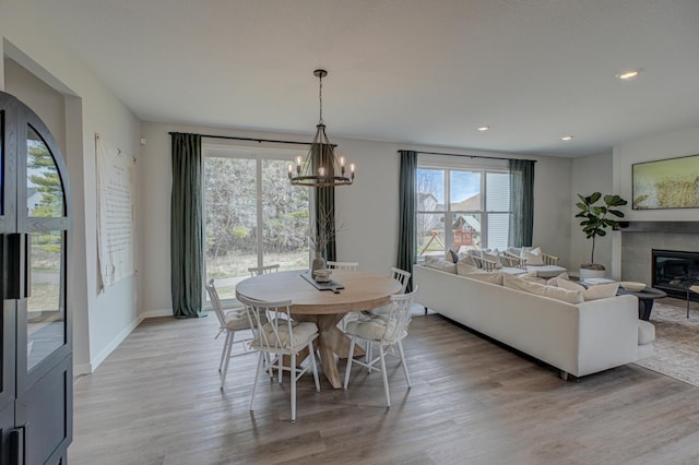 11422 34th St N, Lake Elmo, MN 55042 - dining room featuring a chandelier, light wood-style floors, a tiled fireplace, recessed lighting, and baseboards